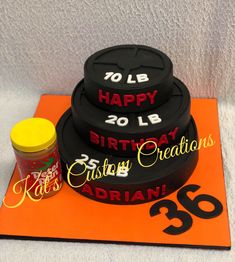 three tiered birthday cake sitting on top of an orange tablecloth with the number thirty