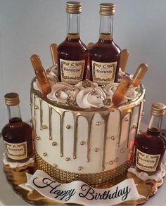 a birthday cake with three bottles of whiskey on top