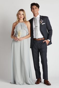 a man and woman in formal wear standing next to each other, posing for the camera