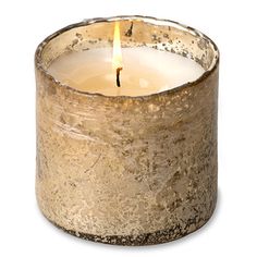 a candle that is sitting inside of a metal container on a white surface with a light in the middle