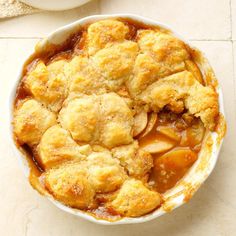 an apple cobbler in a white bowl on a table