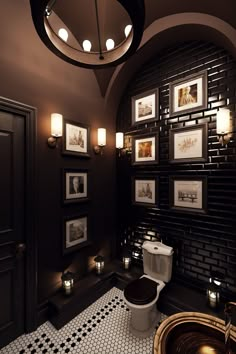 the bathroom is decorated in black and white with pictures on the wall above the toilet