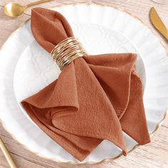 a plate with napkins and goldware on it