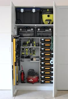 an organized garage storage unit with tools and other items in the cabinet, including toolboxes