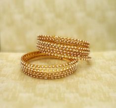 "❖ ❖ ❖ Features: ❖ An Indian styled beaded bangles. ❖ Made from fine Quality Brass with Gold Platting. ❖ Ready to be given as a gift. ❖ Easy and Convenient way to Wear ❖ It looks prettier than the images. Direct Images on hand is also attached. Size of Bangle & Other Details ❖ Size:- 2.5\" approx / Choose Your Size ❖ Quantity:- 12 Bangle Set ❖ Material:- Fine Quality Brass with Gold Platting This gold plated unique bracelet is glamorously impressive, yet subtle, the design is clean and extre Heavy Yellow Gold Bangle For Diwali, Gold-tone Bangle For Party, Festive Heavy Gold-plated Bangle, Festive Yellow Gold Tilla Bangle, Gold-plated Bollywood Bangle, Bridesmaid Party, Black Beaded Jewelry, Pearl Bangle, Bangles Indian