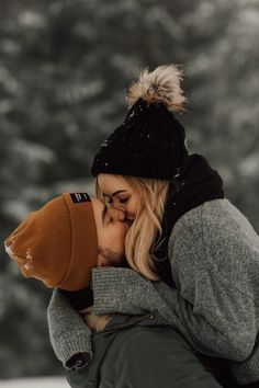 a man and woman kissing in the snow