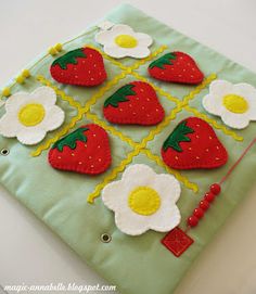 an applique with strawberries, eggs and flowers on green fabric is sitting on a white surface