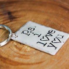 a close up of a keychain on a wooden table with a price tag