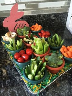 a table topped with lots of different types of vegetables and fruits next to a bunny cutout