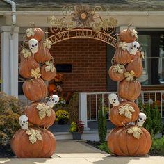 pumpkins stacked on top of each other in front of a house