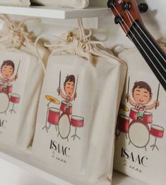 three bags with cartoon children playing drums on them