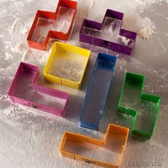 several different colored plastic trays sitting on top of a metal table covered in snow