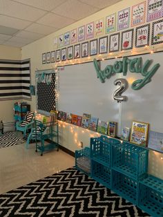 an empty classroom with posters on the wall and blue benches in front of it,