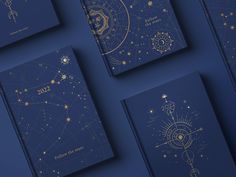 four books with gold stars and zodiac signs on them, all lined up against a blue background