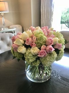 a vase filled with pink and white flowers on top of a table