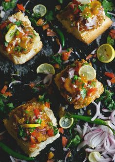 several pieces of bread with various toppings on it and some sliced up lemon wedges