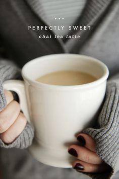 a person holding a cup of coffee in their hands with both hands on the mug