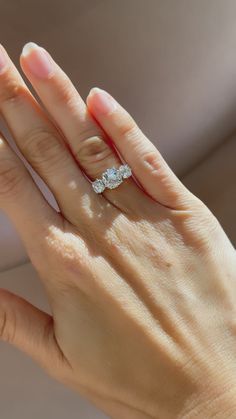 a woman's hand holding an engagement ring