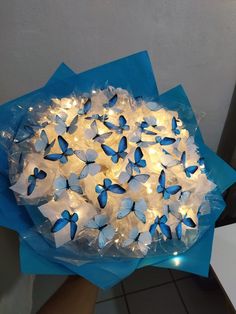 blue and white butterflies are wrapped in plastic with fairy lights on them as decoration for a birthday party