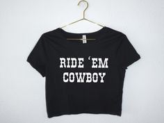 "This \"Ride Em\" Western cropped top tee country inspired Bella Canvas shirt will be your new favorite way to celebrate your next country concert, rodeo, festival or Nashville trip.  This crop tee has a slim fit and it's cut just above the belly button to show off the figure.  Please note this shirt runs small. It's meant to fit like a tight crop top, so please check sizing  We don't accept returns or exchanges. Message us for custom or bulk orders. Every item is custom produced, made to order, Fitted Text Print Top For Concert, Hip Hop Slogan Top For Concert, Fitted Band Merch Shirt With Text Print, Band Merch Graphic Crop Top, Fitted Letter Print Tops For Concerts, Unisex Band Merch Top With Text Print, Unisex Band Merch Tops With Text Print, Cotton Short Sleeve Crop Top For Concert, Cotton Crop Top With Short Sleeves For Concerts