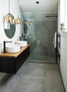 a bathroom with two sinks and a large mirror on the wall above it is also a walk in shower