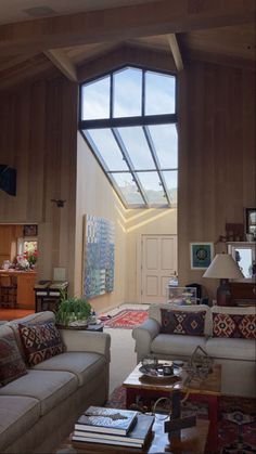 a living room filled with furniture and a skylight in the middle of the room