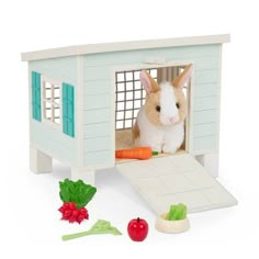 a small rabbit in a toy house with carrots and lettuce