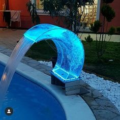 an illuminated fountain in the middle of a swimming pool