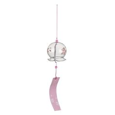 a wind chime with a pink ribbon hanging from it's side and a white background