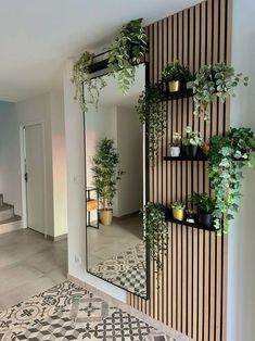 there is a mirror and some plants on the wall in this room with black and white tiles