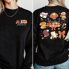 a woman wearing a black sweater with cartoon characters on it and the words nurse in orange