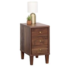 a wooden night stand with two drawers and a white lamp on top of the end table