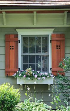 a window with wooden shutters and flower boxes