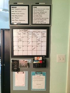 a bulletin board with notes and magnets attached to the side of it in front of a door