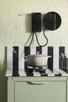 a stove top oven sitting on top of a counter next to a wall mounted hair dryer