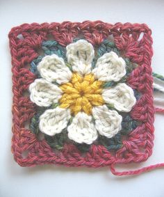 a crocheted square with a flower on it