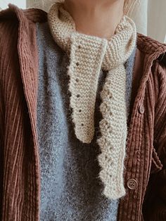 a woman is wearing a knitted scarf