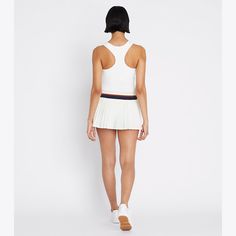 Our best-selling Pleated Tennis Skirt is updated with a mini silhouette. Lightweight and breathable, the classic design is also moisture wicking with great stretch and recovery. A striped elastic waistband and built-in boy short ensure comfort and ease of movement. Sporty Short Tennis Dress, Striped Fitted Short Length Skort, Sporty Mini Tennis Skirt, Sporty Shorts With Banded Waist, Sporty Fitted Short Tennis Dress, Sporty Short Fitted Tennis Dress, Sporty Mini Shorts With Elastic Waistband, White Sporty Mini Length Shorts, Sporty White Mini Length Shorts