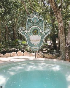 a large hamsa hanging from the side of a pool