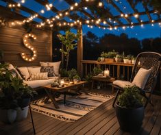 an outdoor deck with lights strung over it and furniture on the ground, surrounded by potted plants