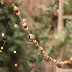 a string with bells hanging from it next to a christmas tree