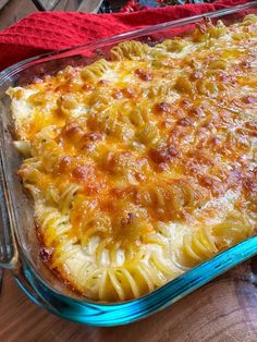 a casserole dish with pasta and cheese in it on a wooden table top