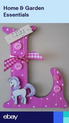 the letter e is decorated with buttons and a unicorn on it's tail, as well as a bow