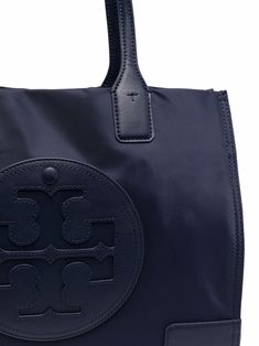 Navy blue small Ella tote bag from TORY BURCH featuring logo patch to the front, magnetic fastening, two rounded top handles and internal zip pocket. | Tory Burch small Ella tote bag Ella Tote, Tory Burch Ella, Nylon Tote Bag, Tory Burch Tote, Blue Tote Bag, Nylon Tote Bags, Blue Tote, Small Tote Bag, Upcycled Materials