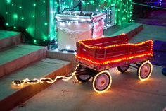 a red wagon with christmas lights attached to it