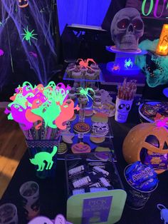 a table topped with lots of halloween treats and decorations on top of a wooden table