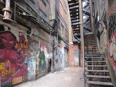 an alleyway with stairs and graffiti on the walls