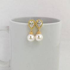 Simply Classic!!  I've created these charmings classic cubic zirconia and pearl bridal earrings in gold plated brass setting. Earrings feature teardrop clear cubic zirconia ear post and 10mm Swarovski pearl dangle drop. Total length of the earrings is 2.7 cms.For matching necklace click:https://www.etsy.com/listing/275221942/gold-pearl-and-crystal-bridal-necklace?ref=shop_home_active_15To browse my collection click :https://www.etsy.com/ shops/fantasycrystals Gold Pearl Bridal Earrings For Anniversary, Gold Pear-shaped Bridal Earrings With Pearl Charm, Gold Bridal Earrings With Pearl Charm For Anniversary, Gold Cubic Zirconia Bridal Earrings, Gold Earrings With Pearl Charm And Cubic Zirconia, Yellow Gold Crystal Earrings For Wedding, Yellow Gold Pearl Earrings With Cubic Zirconia For Wedding, Gold Dangle Pearl Earrings With Cubic Zirconia, Classic Gold-plated Pearl Drop Bridal Earrings