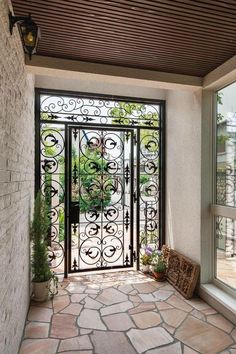 an iron gate is open to let in light into the room with stone flooring