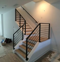 an empty room with white walls and wooden stairs in the process of remodeling